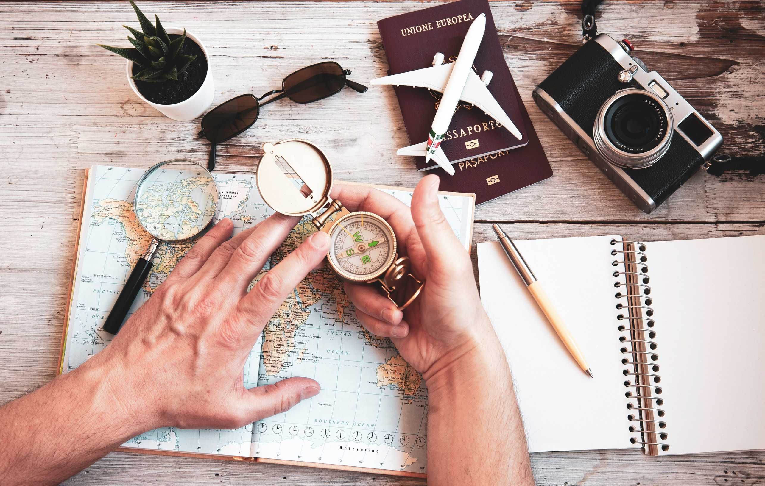 Young Man Planning World Tour With Vintage Travel Map Backpacker